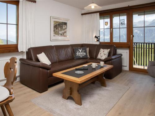a living room with a brown couch and a coffee table at Apartment La Siala Apt-51 by Interhome in Falera