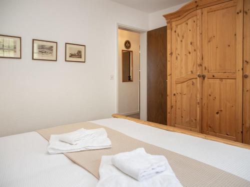 a bedroom with a bed with two white towels on it at Apartment La Siala Apt-51 by Interhome in Falera