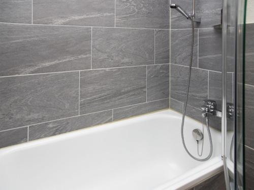 a bathroom with a shower with gray tiles at Apartment La Siala Apt-51 by Interhome in Falera