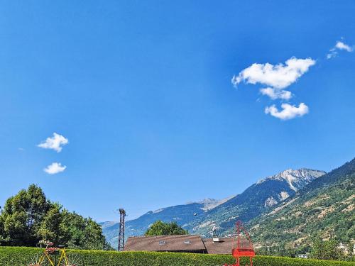 a house with mountains in the background with a blue sky at Apartment Bellentre Chalet le Pommier 5 by Interhome in Bellentre