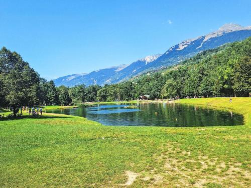 a lake in a field with mountains in the background at Apartment Bellentre Chalet le Pommier 5 by Interhome in Bellentre