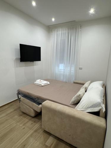 a bedroom with a bed and a couch and a flat screen tv at Dimora Appia in Rome
