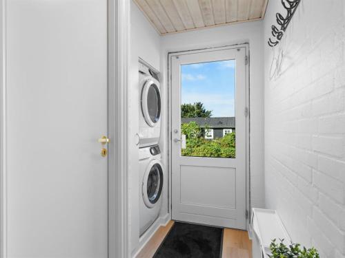 a door to a laundry room with a washing machine at Holiday Home Erle - 830m from the sea by Interhome in Nyby