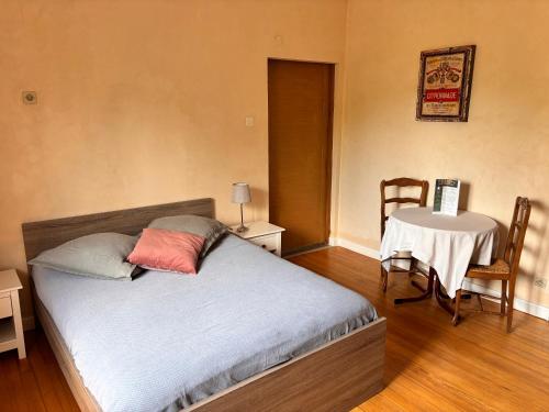 a bedroom with a bed and a table with a chair at Chambre double dans Auberge Alsacienne in Scherwiller