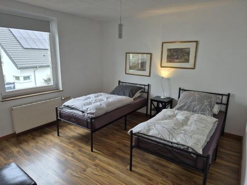 two beds in a room with a window at Werreufer 3bed in Detmold