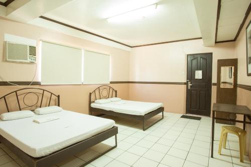 a hospital room with two beds and a window at GV Hotel - Masbate in Masbate