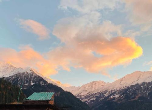a view of a mountain with a rainbow in the sky at Iris cafe and cozy stay in Tosh