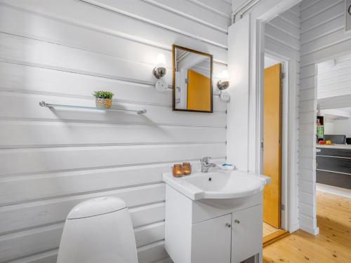 a white bathroom with a sink and a mirror at Holiday Home Blesse - 500m to the inlet by Interhome in Skjern