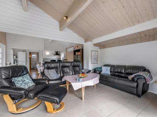 a living room with leather furniture and a table at Holiday Home Blesse - 500m to the inlet by Interhome in Skjern