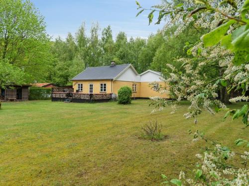 a yellow house in the middle of a yard at Holiday Home Andri - 1-5km from the sea by Interhome in Rønne
