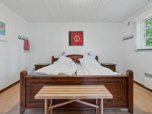 a bed with a wooden frame in a room at Holiday Home Andri - 1-5km from the sea by Interhome in Rønne