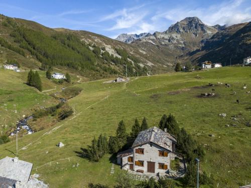 une vieille maison sur une colline dans un champ verdoyant dans l'établissement Chalet Baita Emet by Interhome, à Casone