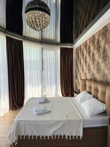 a bedroom with a large bed with a chandelier at Shato mash in Tbilisi City
