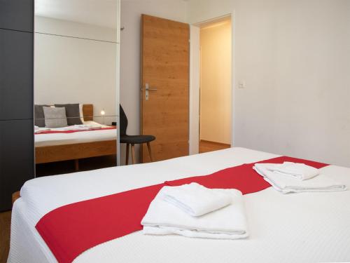a bedroom with a bed with a red and white blanket at Apartment La Siala Apt-7 by Interhome in Falera