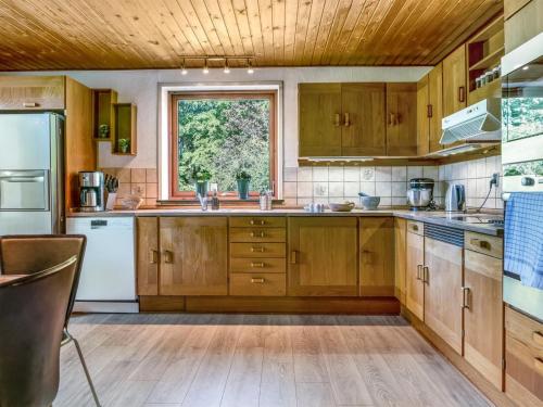 a kitchen with wooden cabinets and a window at Holiday Home Eiko - 400m to the fjord by Interhome in Storvorde