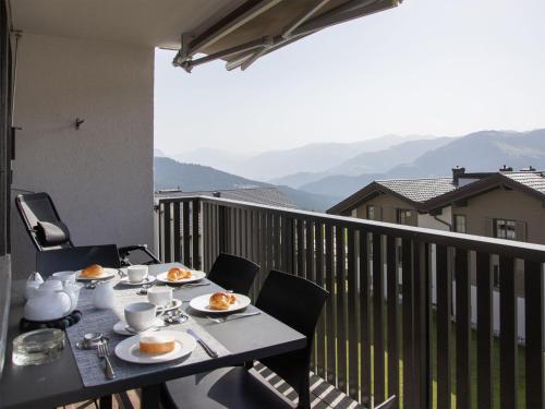 a table with plates of food on a balcony at Apartment La Siala Apt-7 by Interhome in Falera
