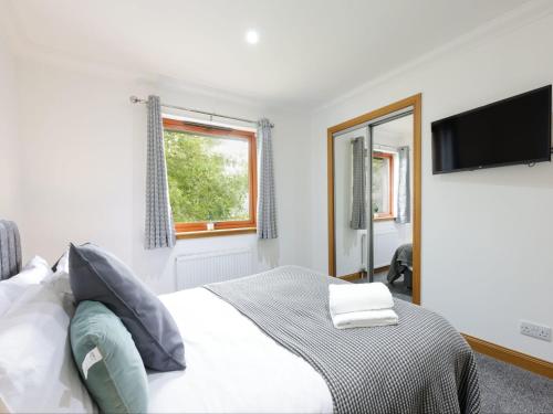 a bedroom with a bed and a flat screen tv at Apartment Forres View by Interhome in Forres