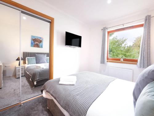 a bedroom with a bed and a mirror at Apartment Forres View by Interhome in Forres