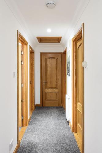 a hallway with wooden doors and a carpet at Apartment Forres View by Interhome in Forres