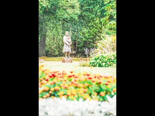 a statue of a woman in a garden with flowers at Apartment Forres View by Interhome in Forres