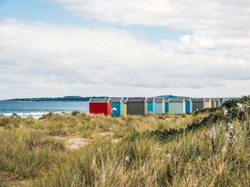 a row of colorful beach huts on the beach at Apartment Forres View by Interhome in Forres