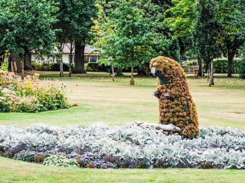 a statue of a bear in a flower garden at Apartment Forres View by Interhome in Forres