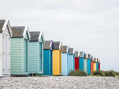a row of colourful beach huts on the beach at Apartment Forres View by Interhome in Forres