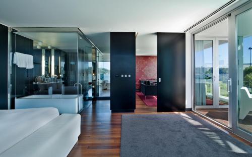 a living room with a white couch and a bathroom at Altis Belem Hotel & Spa, a Member of Design Hotels in Lisbon