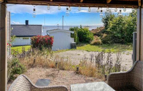 a patio with two chairs and a view of the ocean at Lovely Home In Sandviga With House Sea View in Skarvedalen