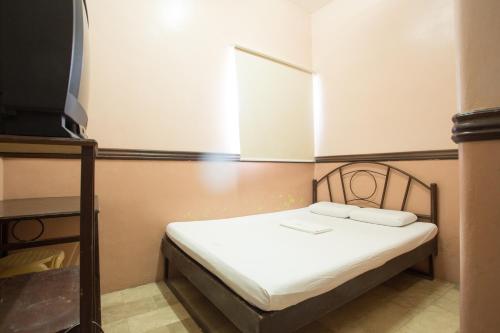a small bed in a room with a window at GV Hotel - Masbate in Masbate