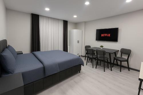 イスタンブールにあるDolapdere Luxury Suites Hotelのベッドとテーブルと椅子のある寝室