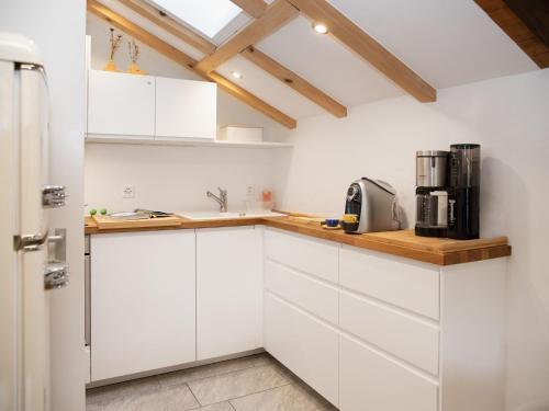 a white kitchen with white cabinets and a window at Apartment La Siala Apt-70 by Interhome in Falera