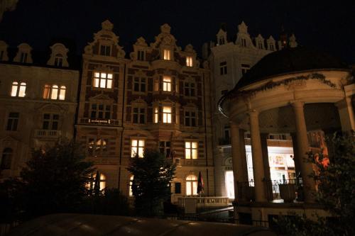 a lit up building with a gazebo at night at Hotel Ester in Karlovy Vary