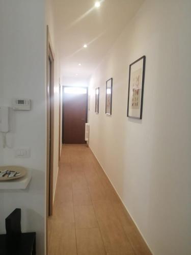 a hallway with white walls and a brown door at Dimora MiRà in Adelfia