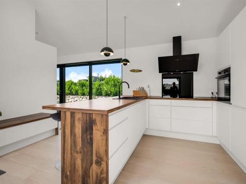a kitchen with white cabinets and a wooden counter top at Holiday Home Merve - 250m from the sea by Interhome in Odder