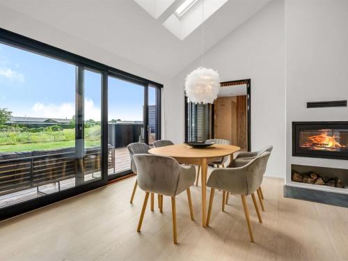 a dining room with a table and chairs and a fireplace at Holiday Home Merve - 250m from the sea by Interhome in Odder