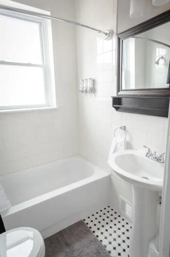a white bathroom with a sink and a toilet at The Chocolate Suite - Walkable and Peaceful home in Tower Grove