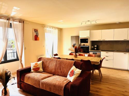 a living room with a couch and a table at Le Terracotta cocon moderne à 2 pas de la Gare ligne directe GENÈVE-LYON-PARIS in Bellegarde-sur-Valserine