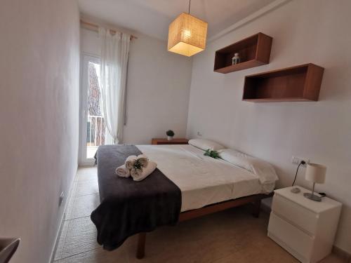 a bedroom with a bed with a ottoman and a window at VILLAS COSETTE - Apartamento Santamaria in Platja  d'Aro