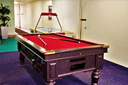 a pool table with a red cover in a room at Classic Coastal Beachfront, Surfers Paradise-Pool in Gold Coast