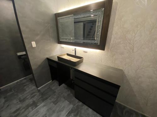 a bathroom with a sink and a mirror on the wall at HIRARI Mizubenomori - Vacation STAY 08869v in Chikugo