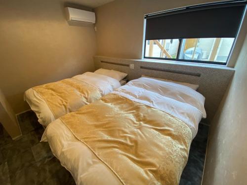 two beds in a room with a window at HIRARI Mizubenomori - Vacation STAY 08869v in Chikugo