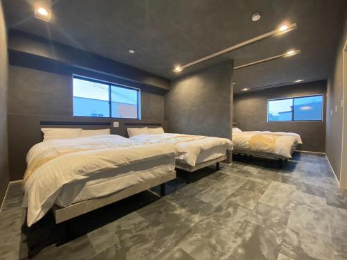 a bedroom with two beds and two windows at HIRARI Mizubenomori - Vacation STAY 08869v in Chikugo