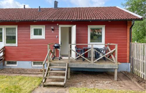a red house with a porch with a table and chairs at Beautiful Apartment In Pauliström in Pauliström