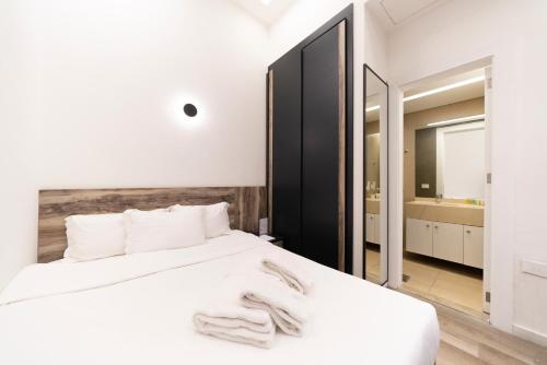 a bedroom with a white bed and a mirror at La Maison De Hamra Hotel Apartments in Beirut