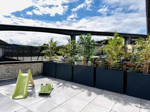 a balcony with green chairs and plants on a building at Le Terracotta cocon moderne à 2 pas de la Gare ligne directe GENÈVE-LYON-PARIS in Bellegarde-sur-Valserine