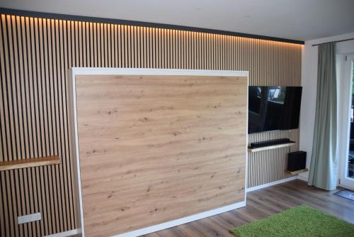 a large wooden closet door in a room with a green rug at Apartment am Spitzingsee in Schliersee