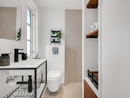 a bathroom with a white sink and a toilet at Holiday Home Urda - 50m from the sea by Interhome in Binderup Strand