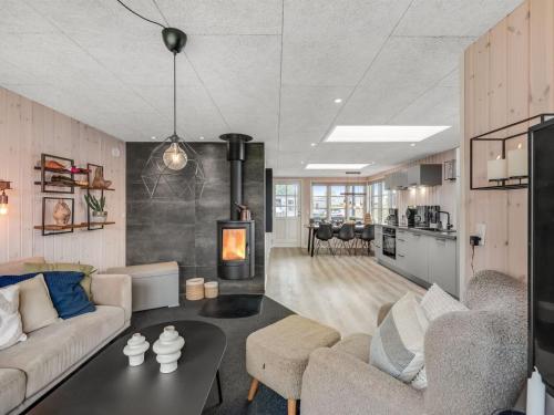 a living room with a couch and a fireplace at Holiday Home Urda - 50m from the sea by Interhome in Binderup Strand