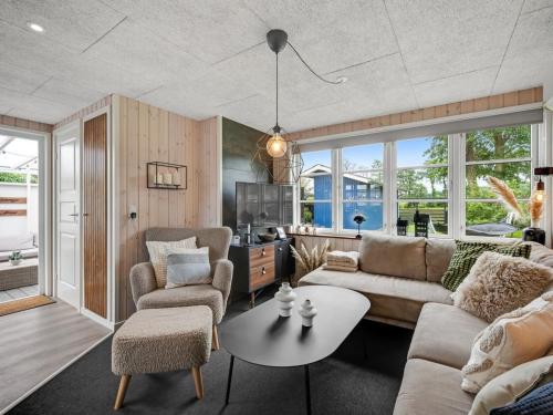 a living room with a couch and chairs and a table at Holiday Home Urda - 50m from the sea by Interhome in Binderup Strand